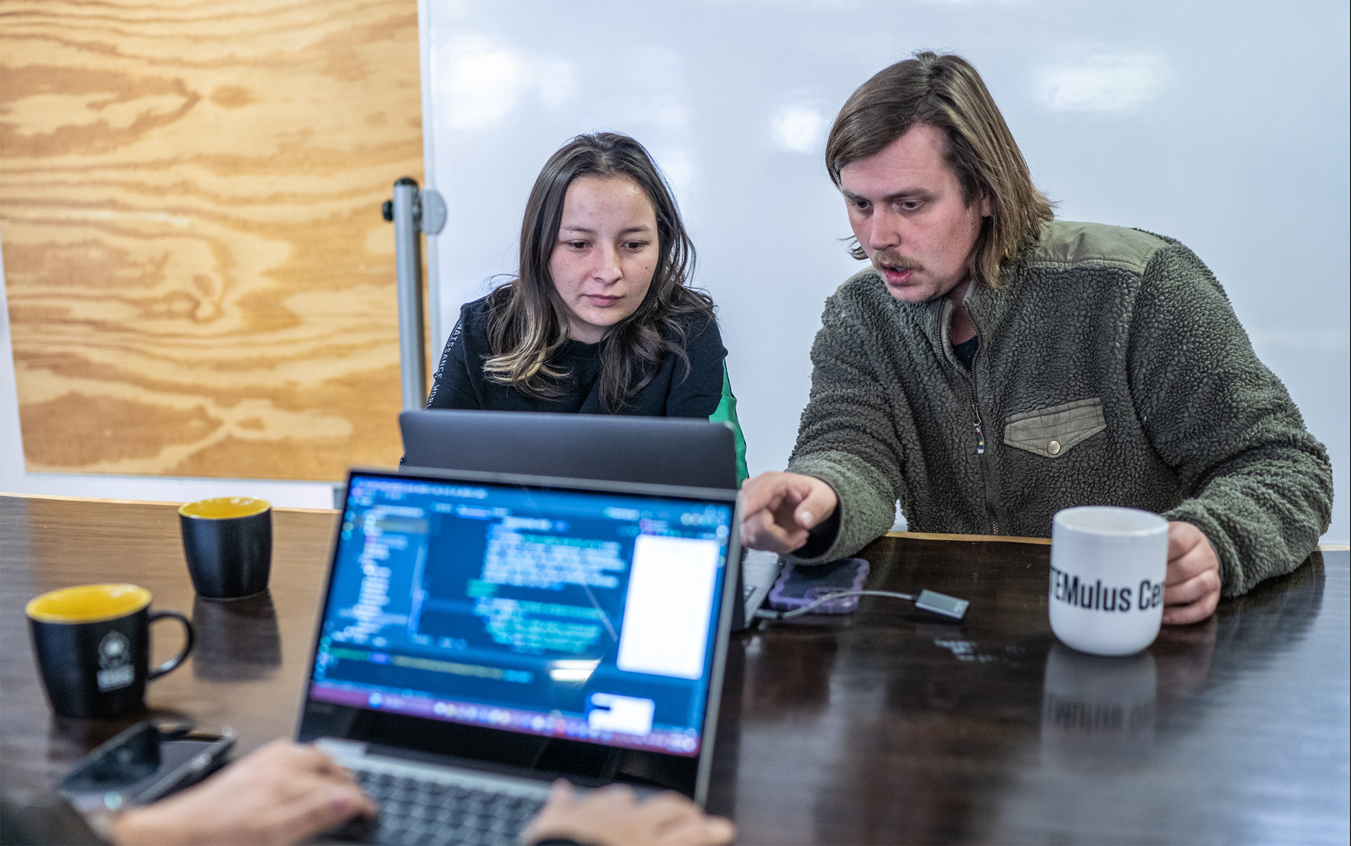 Two Deep Dive UX/UI students on a laptop working together on a UX/UI design project